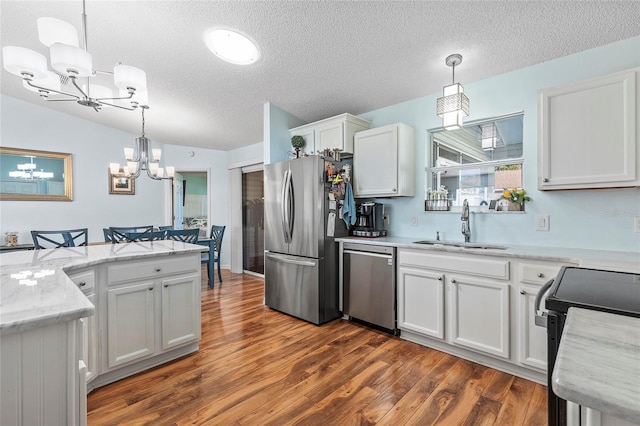 kitchen featuring pendant lighting, dark hardwood / wood-style flooring, white cabinets, and appliances with stainless steel finishes