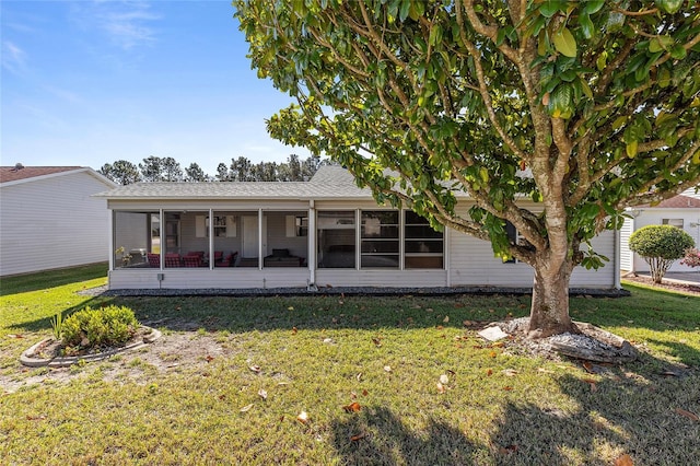 view of front of property with a sunroom and a front yard