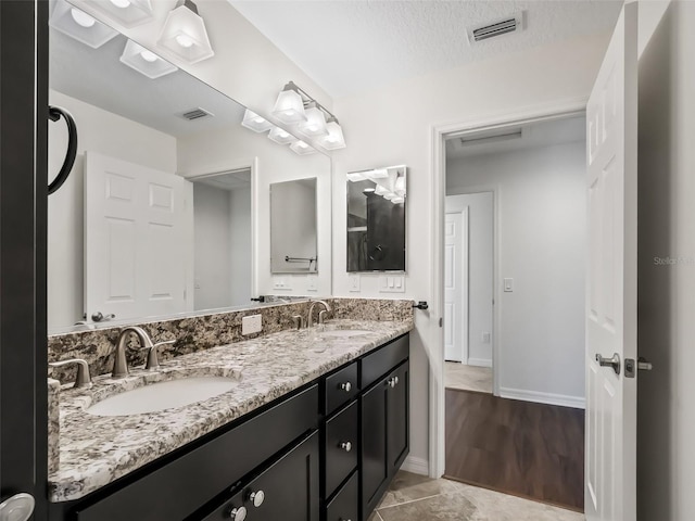 bathroom with vanity, a textured ceiling, and hardwood / wood-style flooring