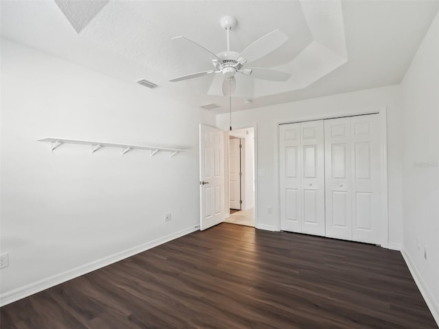 unfurnished bedroom featuring dark hardwood / wood-style floors, ceiling fan, a textured ceiling, and a closet