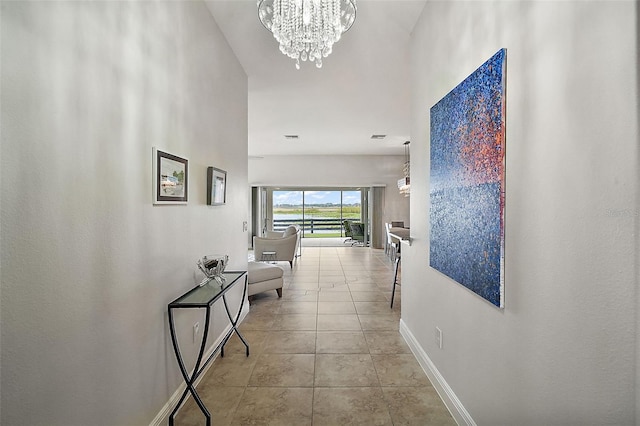 hall featuring light tile patterned floors and an inviting chandelier