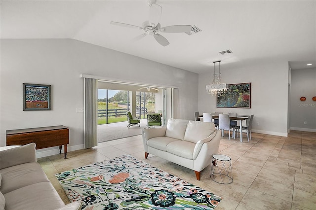 tiled living room with ceiling fan with notable chandelier and lofted ceiling