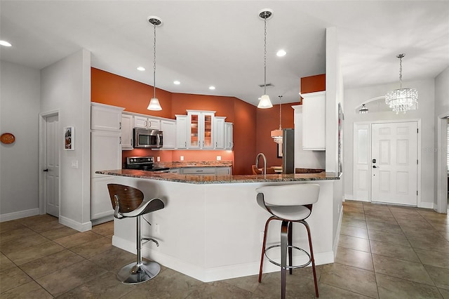 kitchen featuring a kitchen bar, kitchen peninsula, decorative light fixtures, white cabinets, and black / electric stove