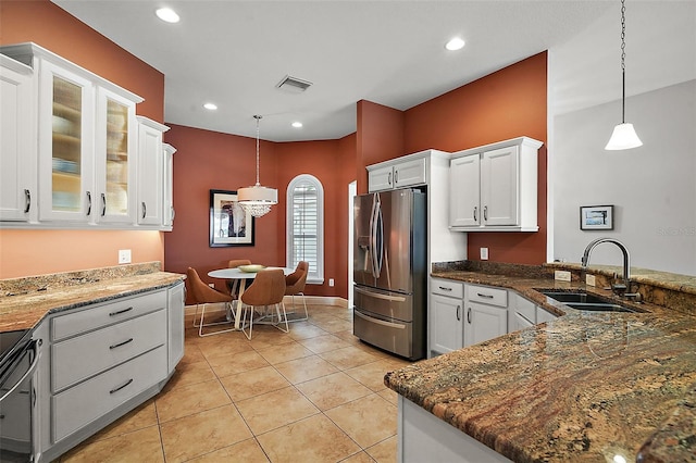 kitchen with pendant lighting, sink, stainless steel refrigerator with ice dispenser, light tile patterned floors, and white cabinetry