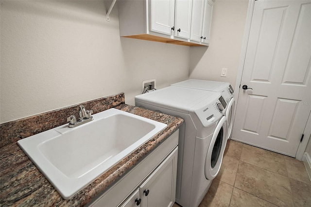 laundry area featuring washer and dryer, light tile patterned flooring, cabinets, and sink