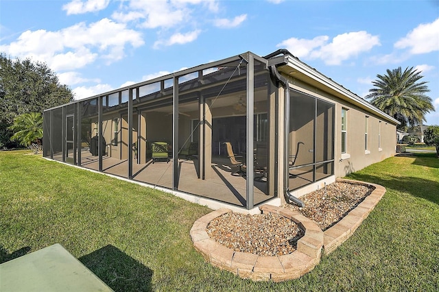 rear view of house featuring a yard, a patio, and glass enclosure