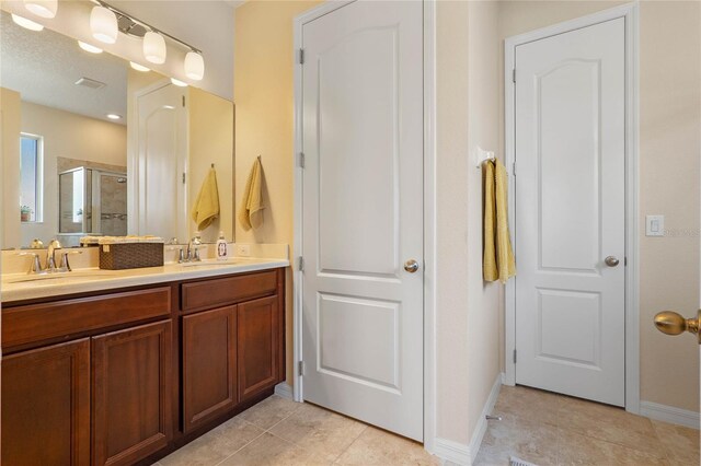 bathroom with tile patterned floors, vanity, and walk in shower