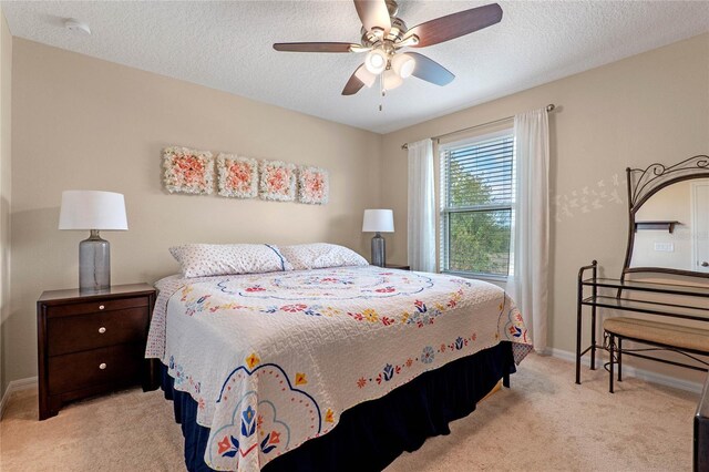 carpeted bedroom featuring ceiling fan and a textured ceiling