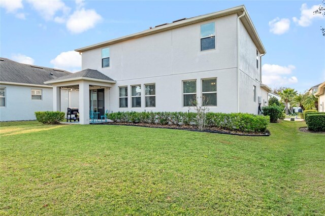 back of house featuring a patio area and a yard