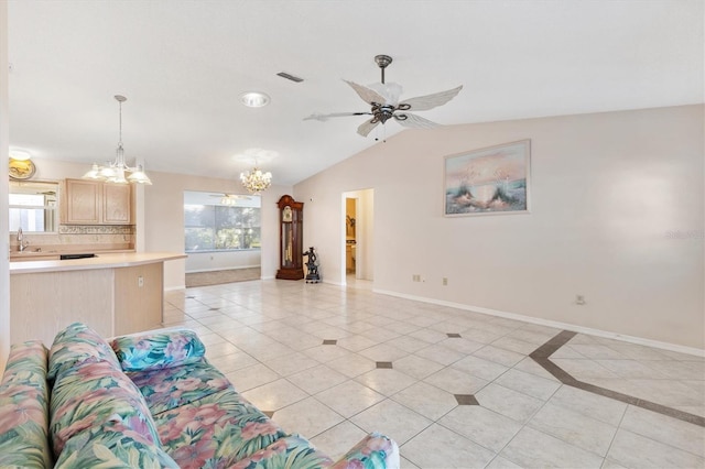 unfurnished living room featuring sink, ceiling fan with notable chandelier, a healthy amount of sunlight, and lofted ceiling