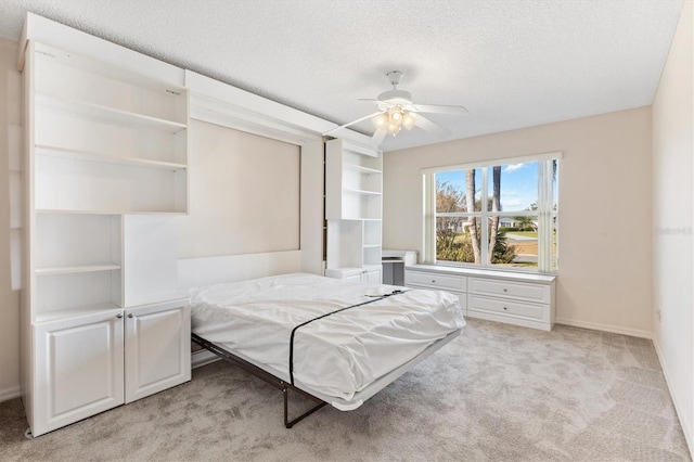 unfurnished bedroom with light carpet, a textured ceiling, and ceiling fan