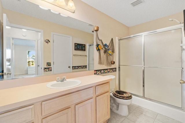 bathroom with walk in shower, vanity, a textured ceiling, tile patterned flooring, and toilet