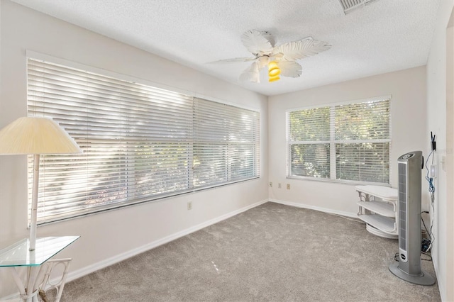 interior space with light carpet, a wealth of natural light, and ceiling fan