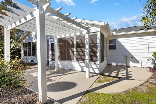 view of patio / terrace featuring a pergola and a sunroom