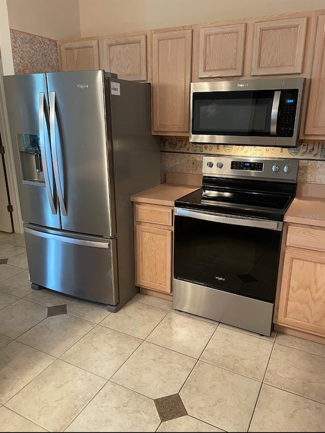 1201 De La Fuente Ct, The Villages, FL 32162 - kitchen with appliances with stainless steel finishes, light brown cabinets, light countertops, and light tile patterned floors