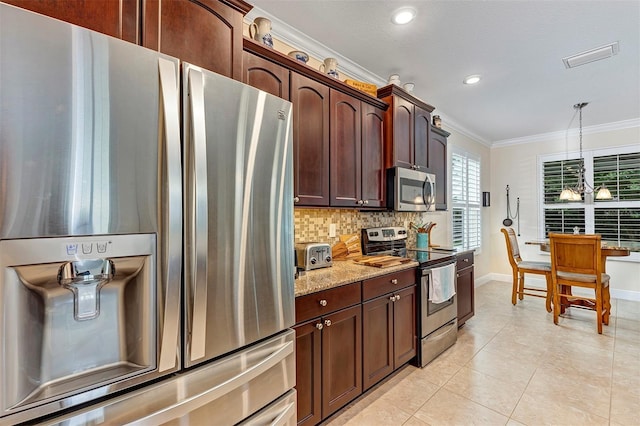 kitchen featuring pendant lighting, light tile patterned floors, light stone countertops, ornamental molding, and appliances with stainless steel finishes