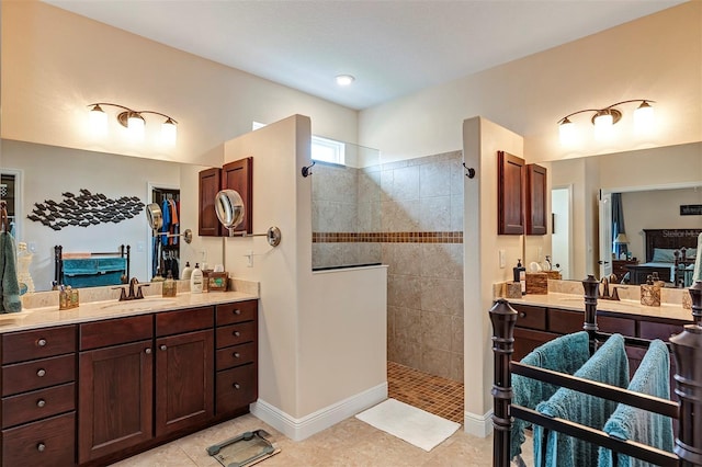 bathroom featuring tile patterned floors, vanity, and a tile shower