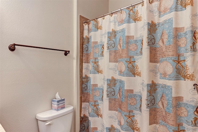 bathroom with a shower with curtain and toilet