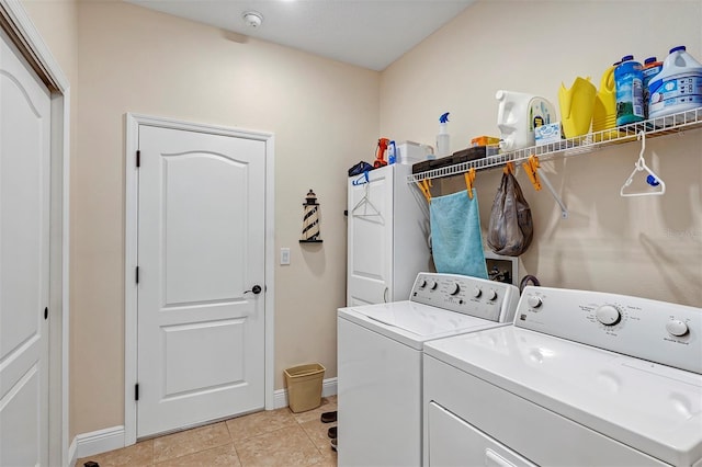 washroom with washer and clothes dryer and light tile patterned flooring