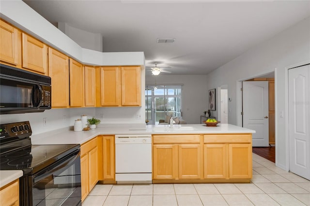 kitchen with sink, kitchen peninsula, light brown cabinets, and black appliances