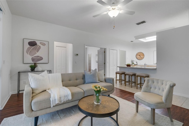 living room with wood-type flooring and ceiling fan