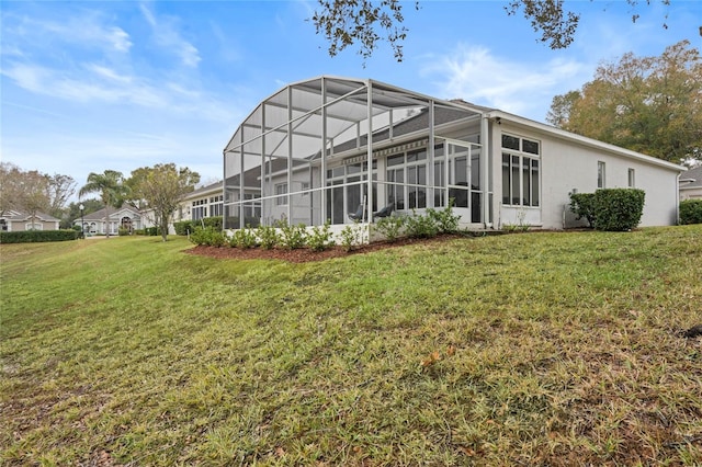 rear view of house featuring a lanai and a lawn