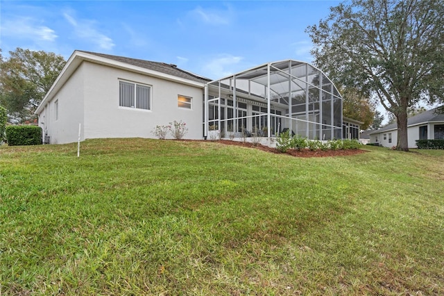 back of house with a lanai and a lawn