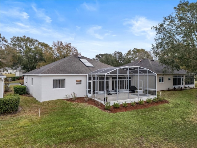 back of house with solar panels, a lanai, a yard, and a patio area