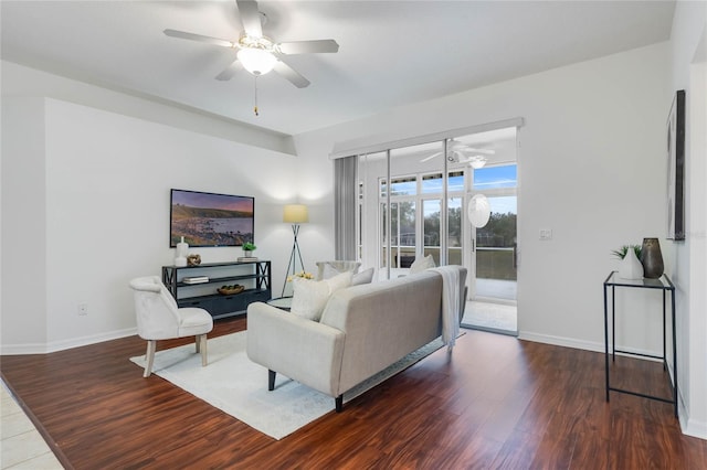 living room with dark wood-type flooring and ceiling fan