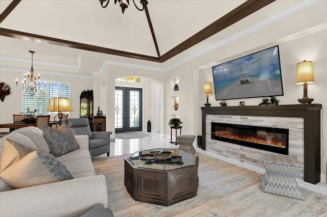 living room featuring french doors, crown molding, a healthy amount of sunlight, and a tiled fireplace