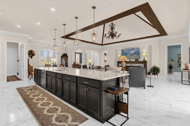 kitchen featuring decorative light fixtures, a spacious island, crown molding, and a breakfast bar area