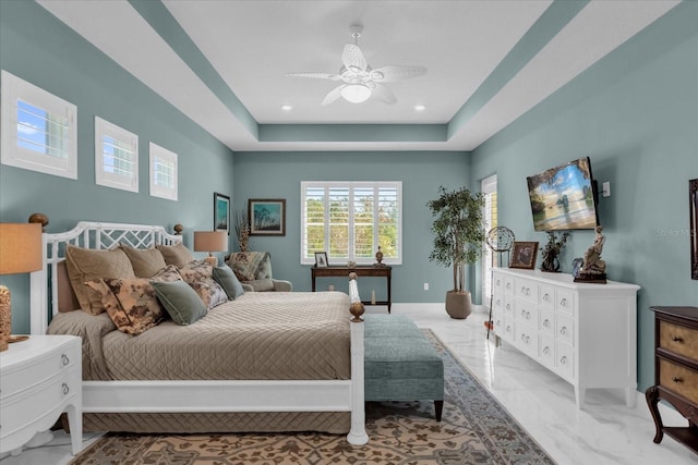 bedroom featuring a raised ceiling and ceiling fan