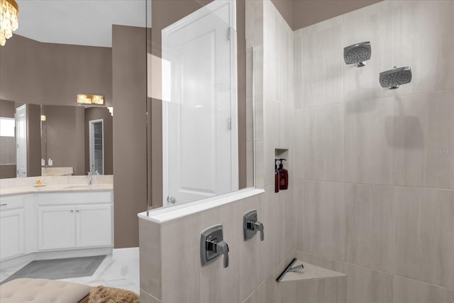 bathroom featuring tiled shower and vanity