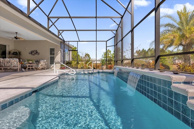 view of pool featuring pool water feature, a patio, glass enclosure, and ceiling fan