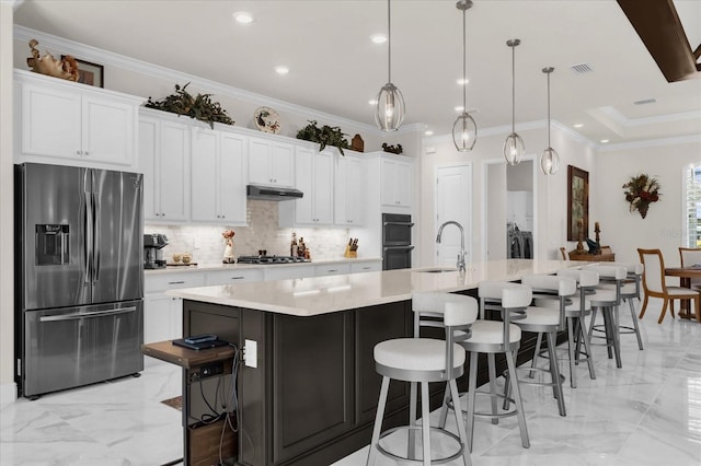 kitchen with decorative light fixtures, a large island, a kitchen bar, white cabinetry, and stainless steel appliances