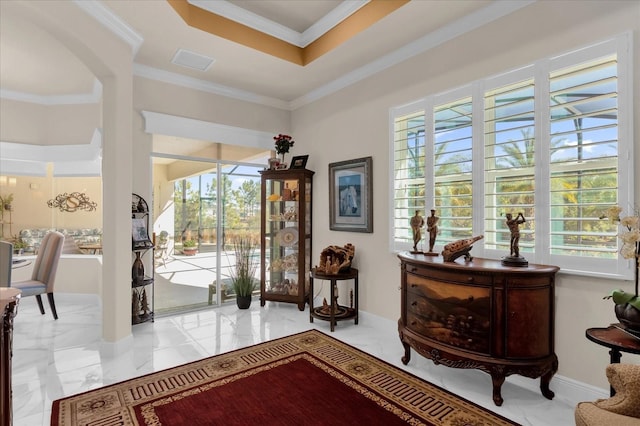 entrance foyer with a raised ceiling and crown molding