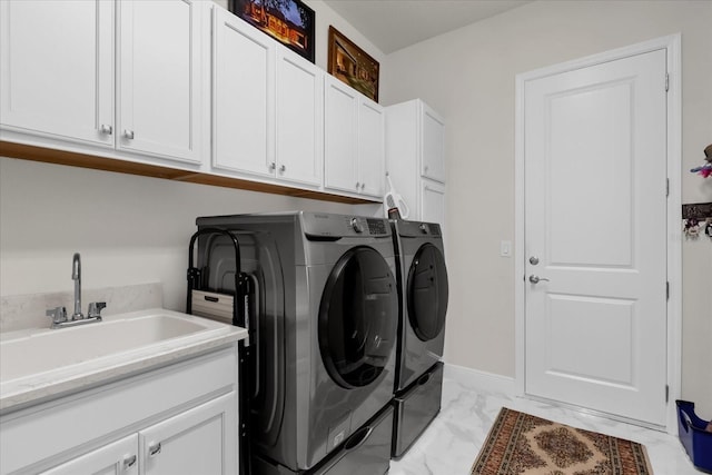 laundry area with washing machine and dryer, sink, and cabinets