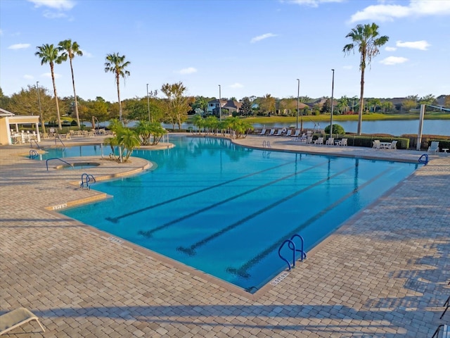 view of swimming pool with a water view and a patio area