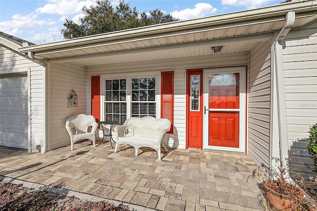 view of exterior entry featuring a garage and covered porch