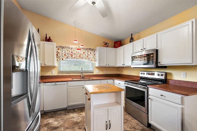 kitchen featuring sink, ceiling fan, appliances with stainless steel finishes, decorative light fixtures, and white cabinetry