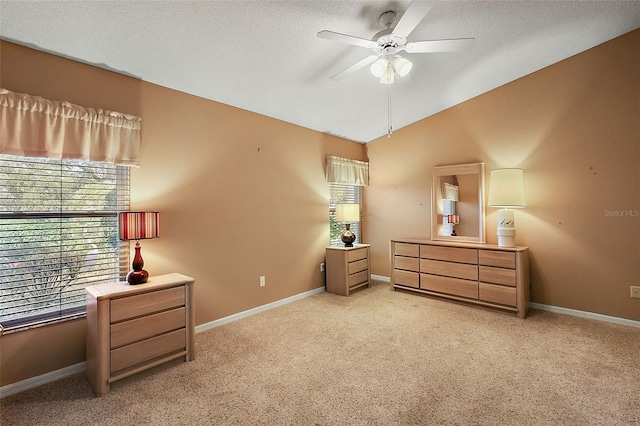 carpeted bedroom with lofted ceiling, ceiling fan, and a textured ceiling