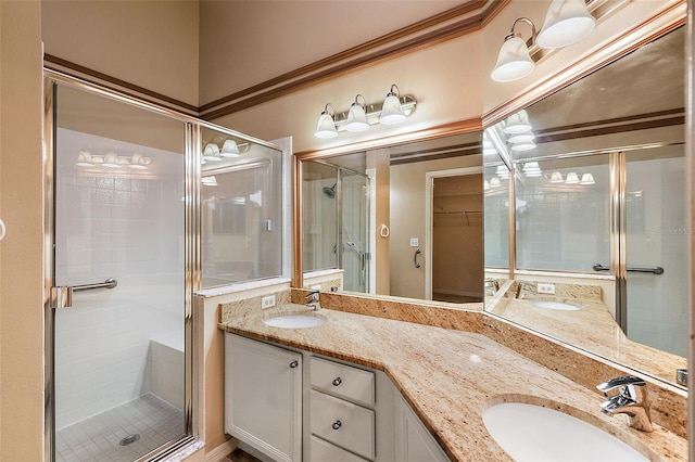 bathroom with vanity, a shower with door, and crown molding