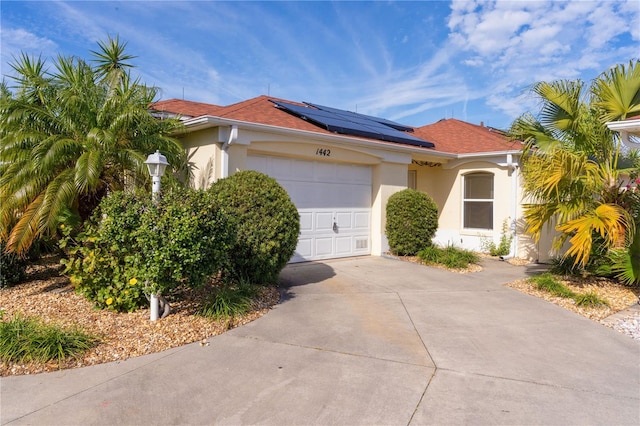 view of front of property with a garage and solar panels