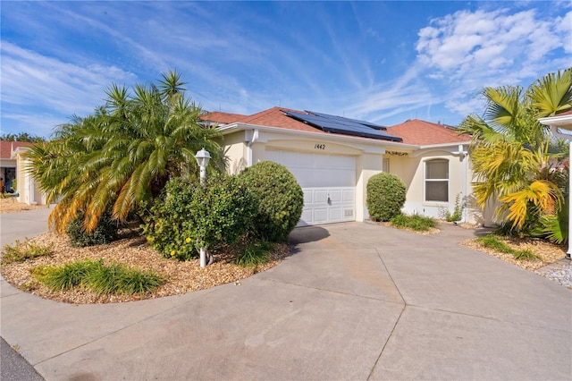 mediterranean / spanish home featuring a garage and solar panels