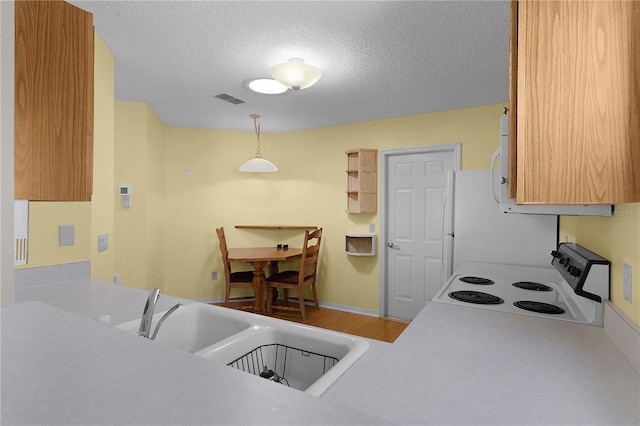 kitchen with pendant lighting, sink, a textured ceiling, white range with electric stovetop, and kitchen peninsula