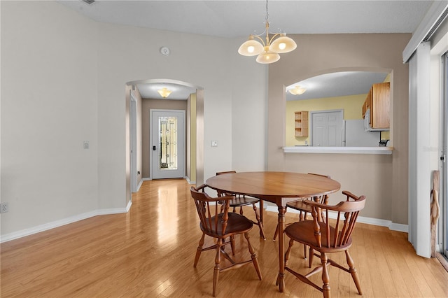 dining room with light hardwood / wood-style flooring and a chandelier