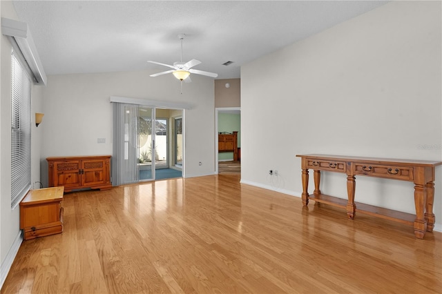 unfurnished living room featuring ceiling fan, vaulted ceiling, and light hardwood / wood-style flooring