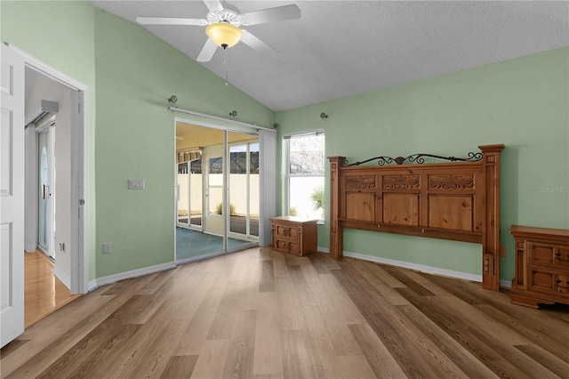 unfurnished bedroom with a textured ceiling, light hardwood / wood-style floors, ceiling fan, and lofted ceiling