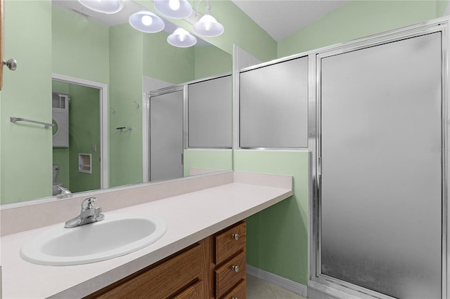 bathroom with vanity, a textured ceiling, tile patterned floors, and a shower with shower door