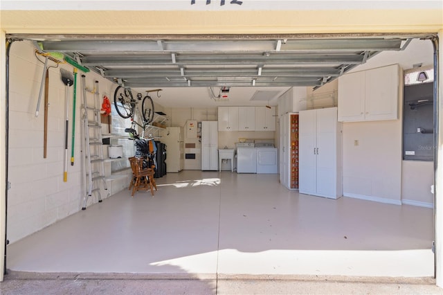 garage with white refrigerator, separate washer and dryer, and sink